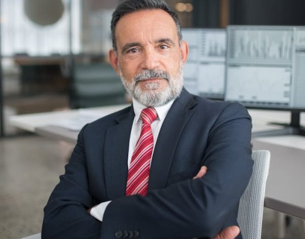 man-in-black-suit-sitting-on-white-chair-8353841